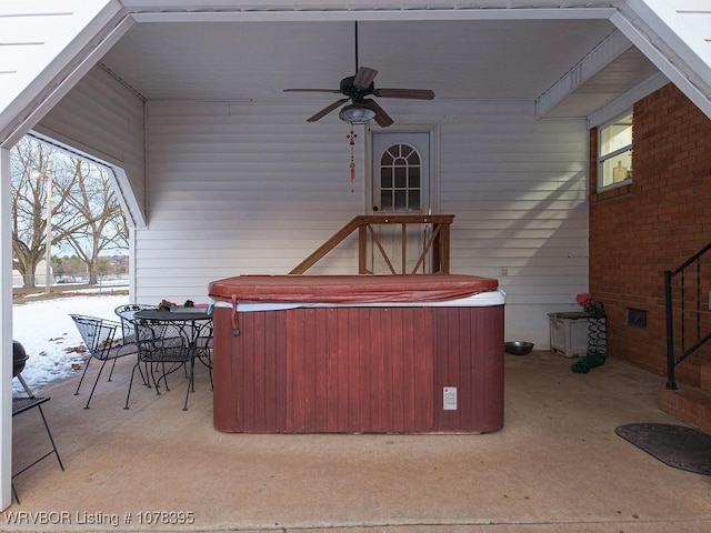 snow covered patio featuring ceiling fan and a hot tub