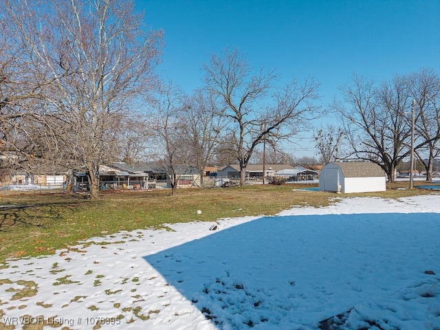 snowy yard featuring a storage unit