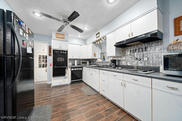 kitchen featuring ceiling fan, range hood, black appliances, white cabinets, and sink