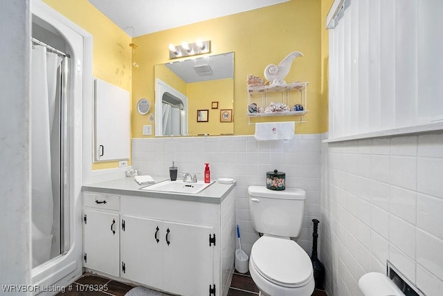 bathroom with tile walls, toilet, vanity, and a shower with shower curtain