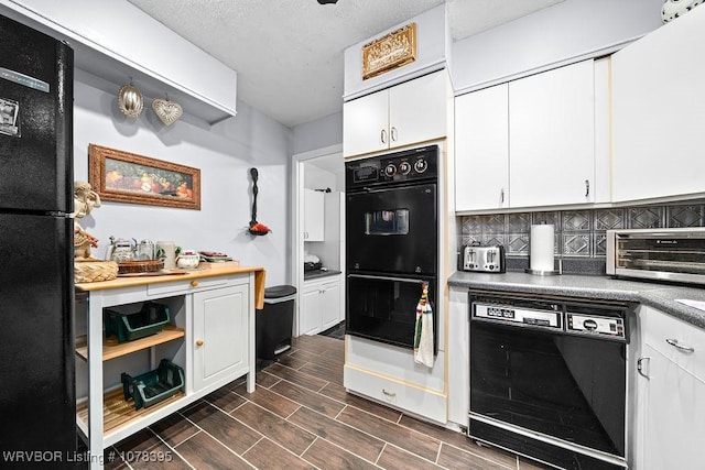 kitchen featuring white cabinetry, black appliances, and tasteful backsplash