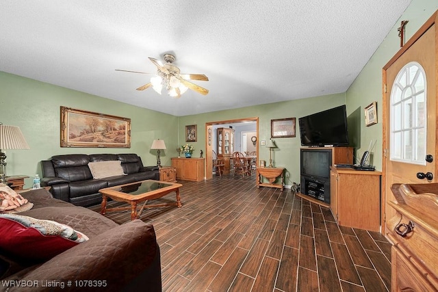 living room with a textured ceiling and ceiling fan