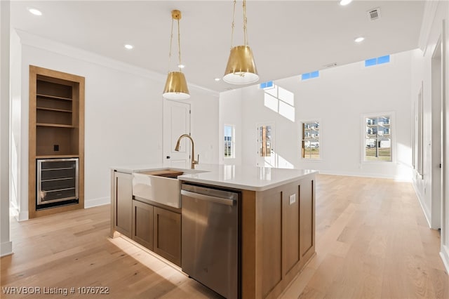 kitchen featuring a kitchen island with sink, sink, dishwasher, wine cooler, and hanging light fixtures