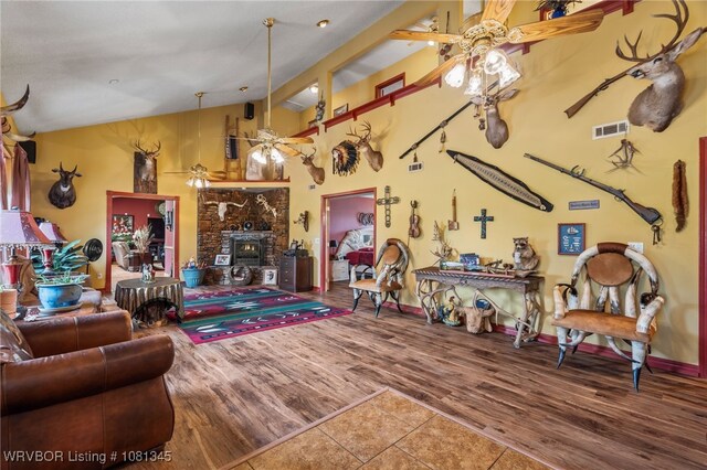 461510 E 1130th Rd, Sallisaw, OK 74955 - living room featuring a ceiling fan, wood finished floors, high vaulted ceiling, a fireplace, and baseboards