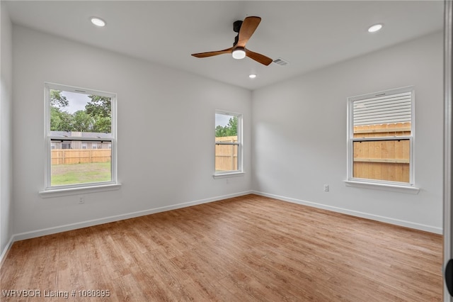 empty room featuring healthy amount of natural light, light wood-style flooring, a ceiling fan, baseboards, and recessed lighting
