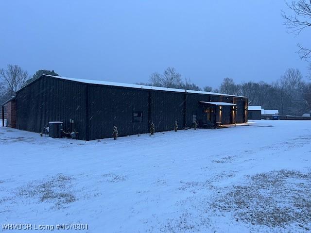 snow covered structure featuring cooling unit