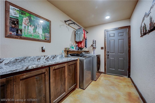 washroom with cabinets and washer and clothes dryer