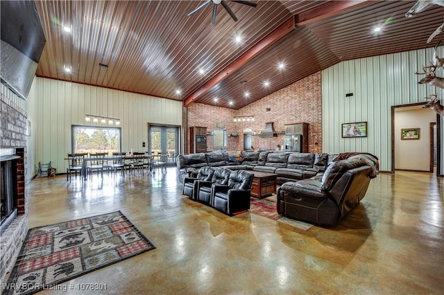 living room featuring ceiling fan, a brick fireplace, high vaulted ceiling, brick wall, and wood walls