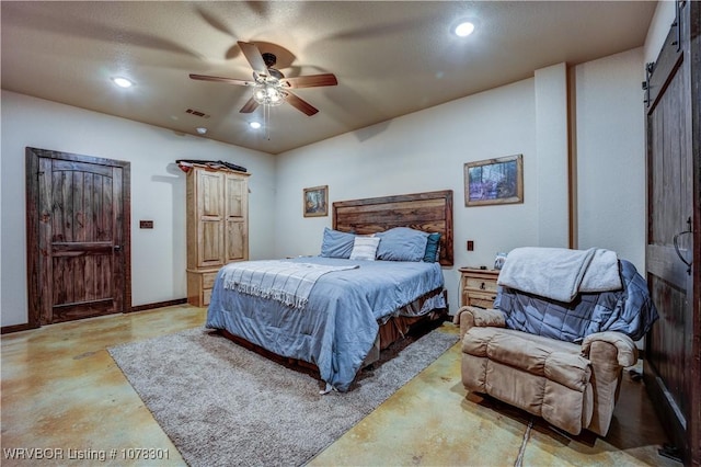 bedroom with ceiling fan and a barn door