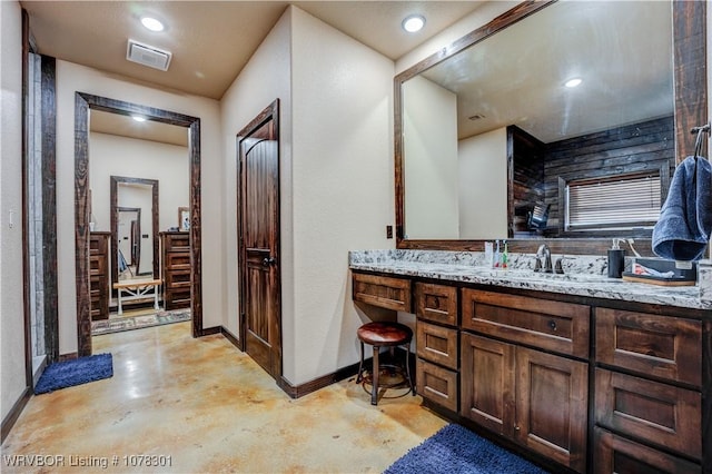 bathroom with vanity and concrete flooring