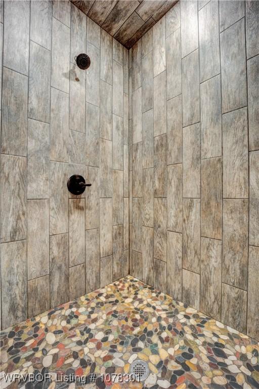 details with a tile shower and wood ceiling