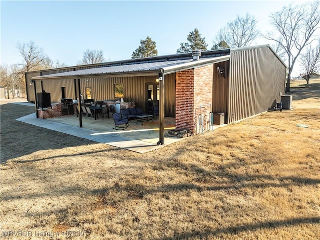 rear view of house with a lawn and a patio