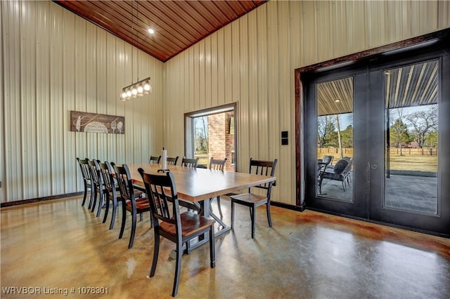 dining area with a chandelier, concrete floors, high vaulted ceiling, and wood ceiling