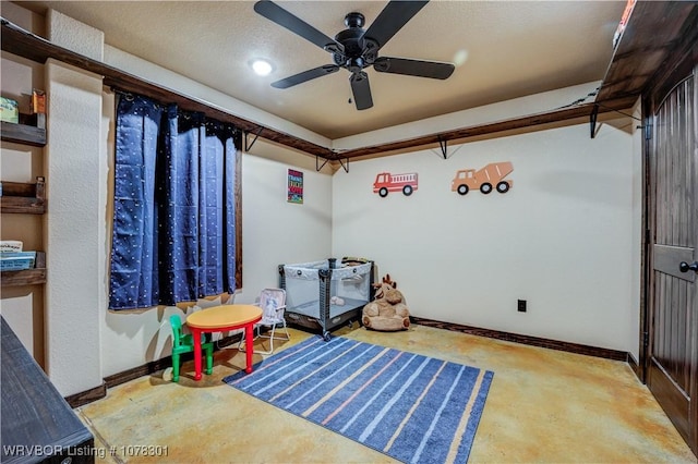 recreation room with ceiling fan and a textured ceiling