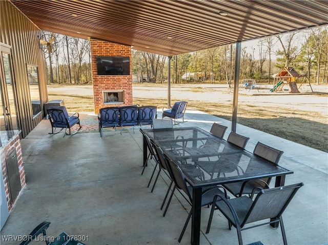 view of patio / terrace featuring an outdoor living space with a fireplace and a playground