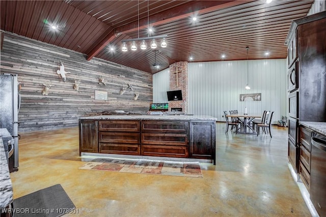 kitchen with wood walls, dark brown cabinets, hanging light fixtures, and appliances with stainless steel finishes