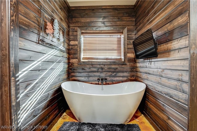 bathroom featuring a tub and wood walls