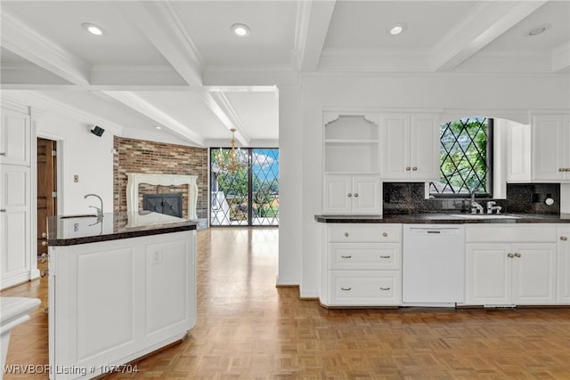 kitchen with white cabinets, beam ceiling, dishwasher, and sink