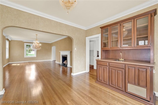 interior space featuring sink, light hardwood / wood-style floors, crown molding, and a chandelier