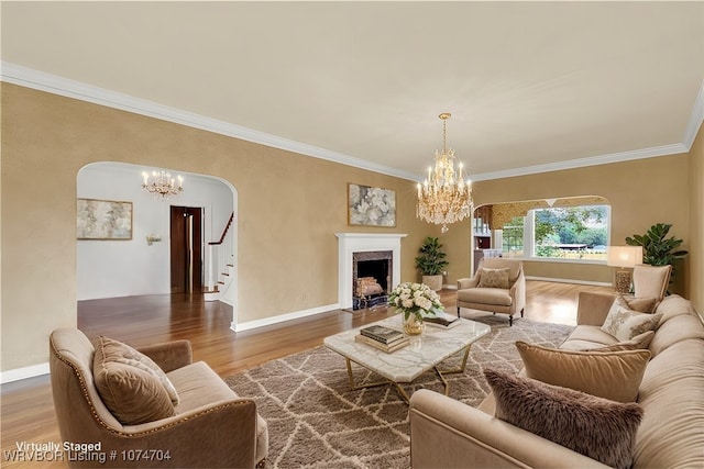 living room with a chandelier, hardwood / wood-style floors, and crown molding