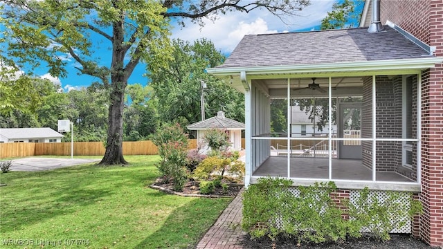 view of yard featuring ceiling fan and a sunroom