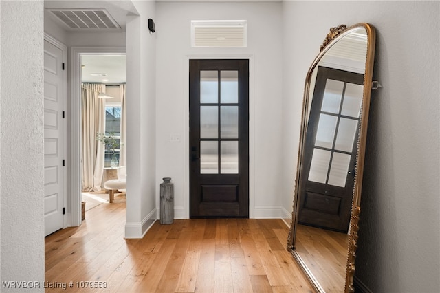 foyer featuring visible vents, baseboards, and light wood-style flooring