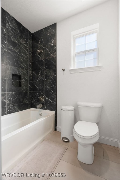 bathroom featuring tile patterned floors, toilet, shower / bathing tub combination, and baseboards