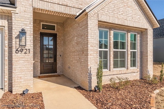 view of exterior entry with brick siding