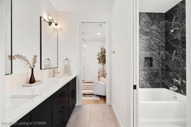 ensuite bathroom with baseboards, double vanity, ensuite bathroom, tile patterned floors, and a sink