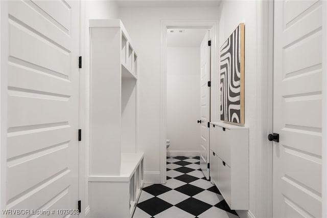 mudroom featuring dark floors and baseboards