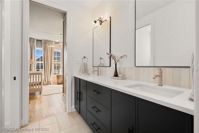 full bath featuring double vanity, tile patterned floors, and a sink