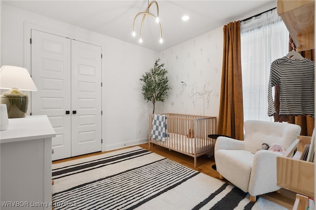 living area with recessed lighting, baseboards, wood finished floors, and wallpapered walls