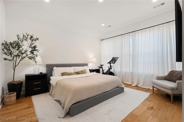 bedroom with recessed lighting, visible vents, lofted ceiling, and light wood-style flooring