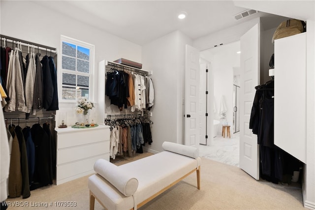 walk in closet featuring visible vents and light colored carpet