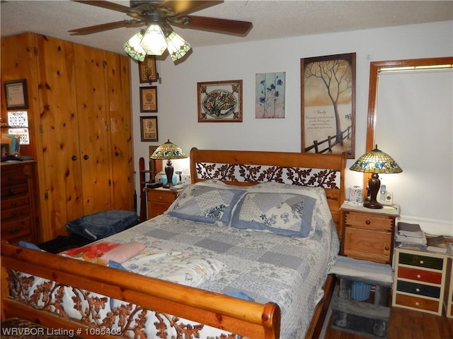 bedroom with wood-type flooring, a textured ceiling, and ceiling fan