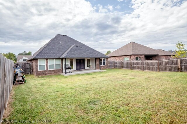 back of property with a patio area and a yard