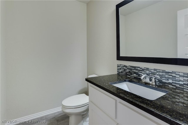 bathroom with decorative backsplash, vanity, and toilet