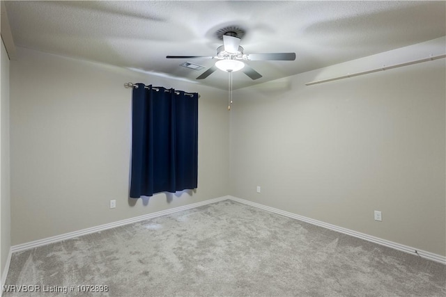 empty room featuring light carpet, ceiling fan, and a textured ceiling