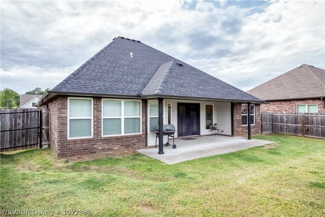 back of property with a lawn and a patio area