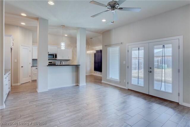 kitchen featuring french doors, ceiling fan, sink, pendant lighting, and white cabinetry