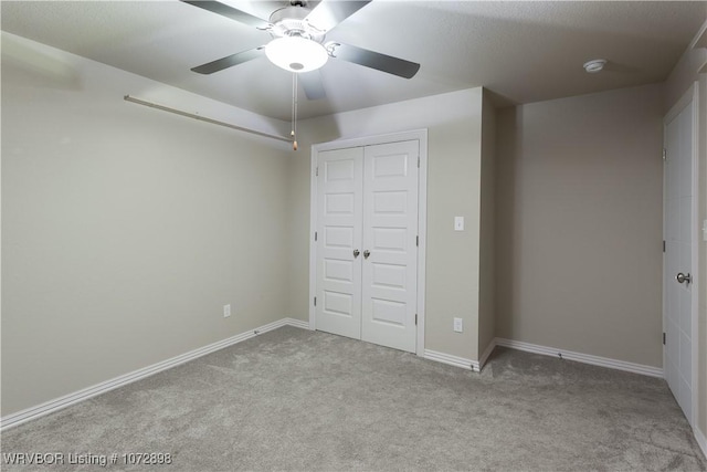 unfurnished bedroom featuring ceiling fan, light colored carpet, and a closet