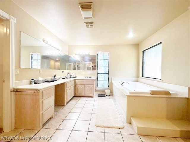 bathroom featuring vanity, tile patterned floors, and a bathtub