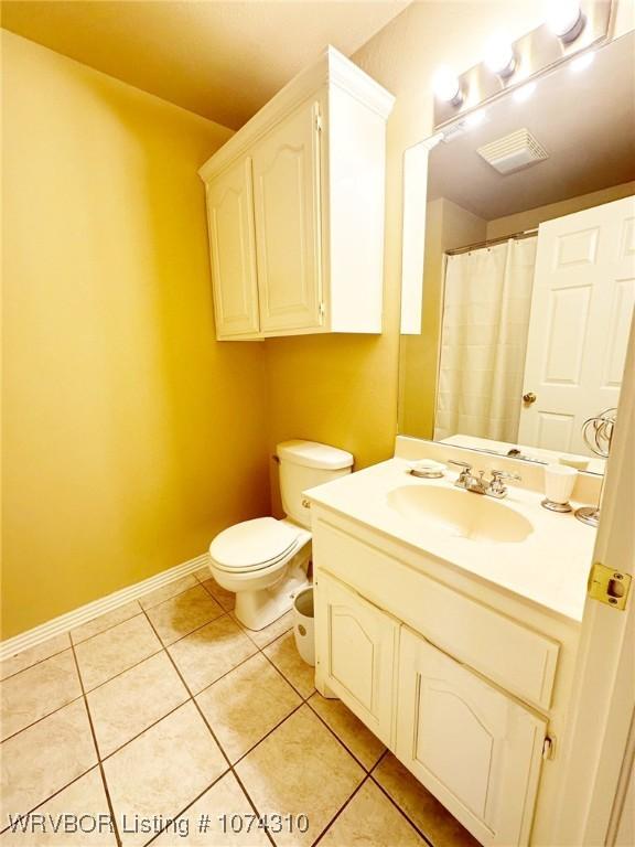 bathroom with tile patterned flooring, vanity, and toilet