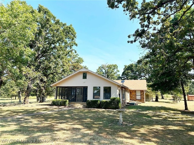 ranch-style home with a front lawn and a sunroom