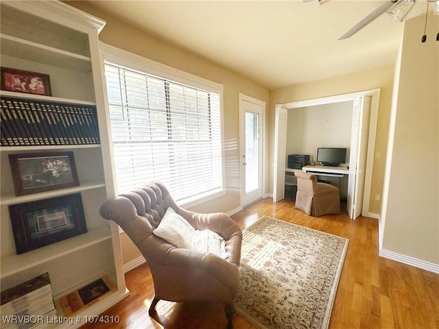 sitting room with light wood-type flooring and ceiling fan