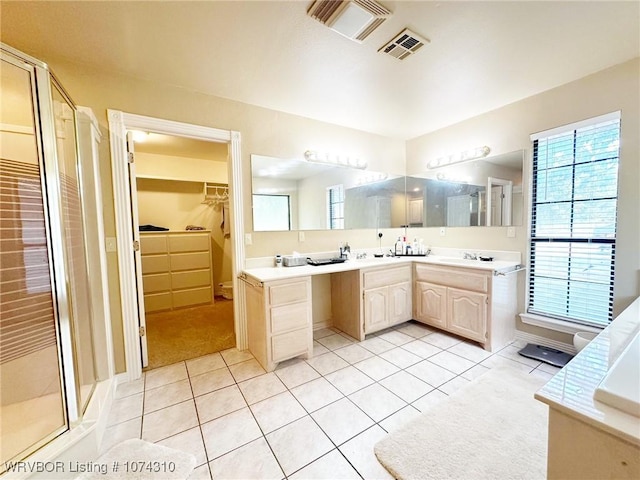 bathroom with tile patterned flooring, vanity, a shower with door, and plenty of natural light