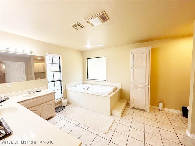 bathroom featuring tile patterned flooring, vanity, and a tub