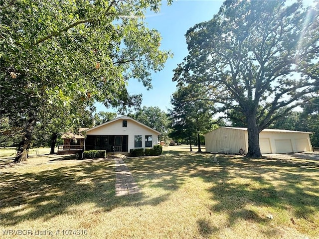 view of yard with an outbuilding, a garage, and covered porch