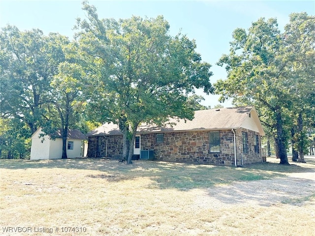 single story home featuring a front yard and central AC unit