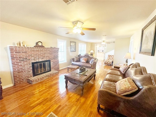 living room featuring a brick fireplace, ceiling fan, and hardwood / wood-style flooring